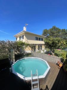 a swimming pool with two chairs and a house at Lagoa House Albufeira in Lagoa de Albufeira