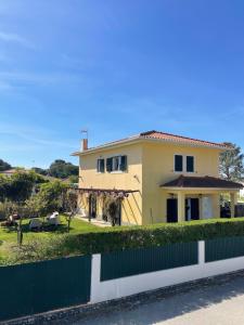 a house with a fence in front of it at Lagoa House Albufeira in Lagoa de Albufeira