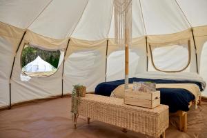 a tent with a bed and a table in it at Hôtel UNIQ - Domaine Saint-Bernard - Tentes Glamping in Mont-Tremblant