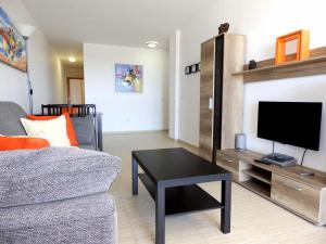 sala de estar con sofá, TV y mesa en Apartamentos Medano - Oeste, en El Médano