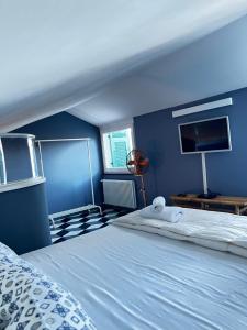 a blue bedroom with a bed and a tv at La Masia in Portovenere