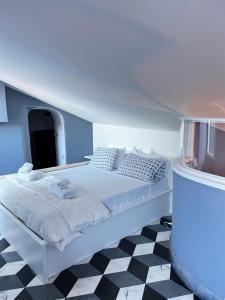 a white bed in a room with a checkered floor at La Masia in Portovenere
