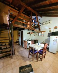 a kitchen and dining room with a table and a refrigerator at Cabañas Desde Las Estrellas in Merlo