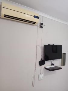 a room with a tv and a computer on a wall at NGEBE Lodge jozini in Jozini