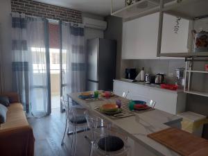a kitchen with a counter with chairs and a refrigerator at DaSimo in Lido di Fermo