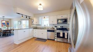 a kitchen with white cabinets and stainless steel appliances at Dog Friendly Oceanfront Home with Hot Tub & Views in Fort Bragg