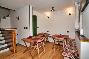a dining room with tables and chairs and a staircase at Alchemist Inn in Gjirokastër
