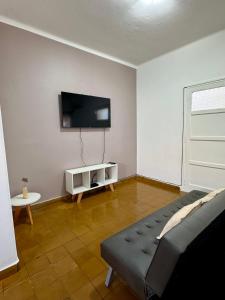 a living room with a couch and a flat screen tv at Departamento Lavanda in San Juan
