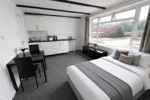 a bedroom with a bed and a desk and a kitchen at Self-contained Studio Slough, Berkshire in Canvey