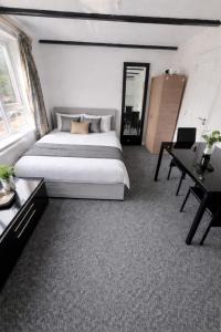 a bedroom with a large bed and a desk at Self-contained Studio Slough, Berkshire in Canvey