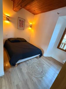 a bedroom with a bed with a black comforter at Maison Bayle in Vignec