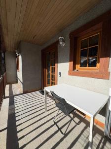 a white bench sitting on the porch of a house at Maison Bayle in Vignec