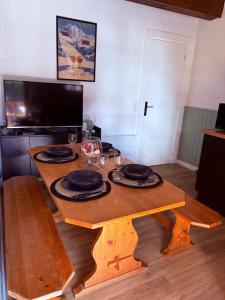 a wooden table with plates and wine glasses on it at Maison Bayle in Vignec