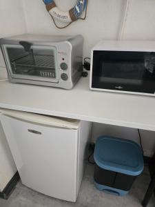 a microwave and a toaster oven sitting on a desk at Ocean 300m Gare Centre ville Wifi Parking gratuit in Belfort +7 photos