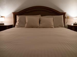 a large bed with white sheets and pillows at Il nido di Lera in Lenno