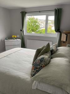 a bed with pillows and a window in a bedroom at 3 Harbour Lights, Newlyn in Penzance