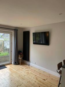 a living room with a flat screen tv on the wall at 3 Harbour Lights, Newlyn in Penzance