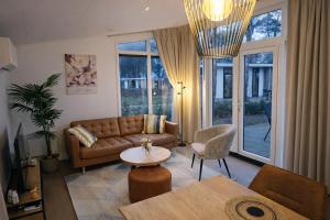 a living room with a couch and a table at Colibri Huisje in Haarle +18 photos