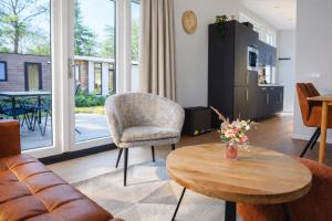 a living room with a table and a chair at Colibri Huisje in Haarle