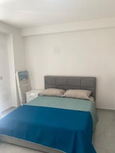 a bedroom with a bed with a blue blanket at BlueWaveapartments 4 in Shëngjin