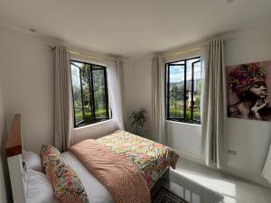 a small bedroom with two windows and a bed at Prime Elgon View 5BR Family Home Private Secure in Eldoret
