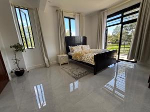 a living room with a bed and large windows at Prime Elgon View 5BR Family Home Private Secure in Eldoret