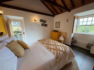 a bedroom with a large bed and a window at Casa do Laureano in Santo Amaro