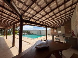 a pavilion with a table and a swimming pool at Casa Cações Beach Marataizes in Marataizes
