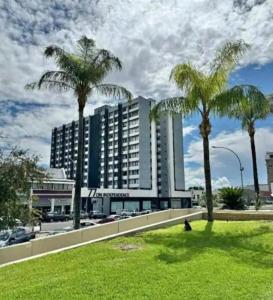 a hotel with palm trees in front of it at Jubilee Stay in Windhoek