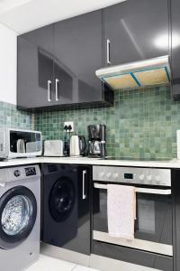 a kitchen with a washing machine and a washer at Jubilee Stay in Windhoek