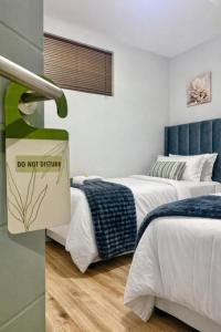 a room with two beds and a do not disturb sign at Jubilee Stay in Windhoek +30 photos