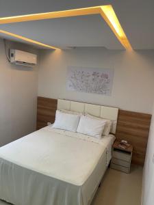 a bedroom with a large bed with white sheets at Casa Lima Premium in Arapiraca
