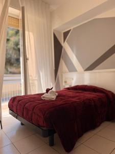 a bedroom with a bed with a red blanket at Hotel Gentile in Noli