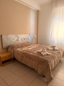 a bedroom with a bed with a purse on it at Hotel Gentile in Noli