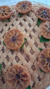 a close up of a pie with orange slices on it at Hotel Gentile in Noli