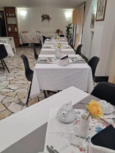 a row of tables in a room with flowers on them at Hotel Gentile in Noli