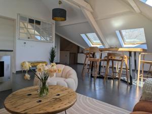a living room with a vase of flowers on a table at Appartement pieds dans l'eau in Doussard