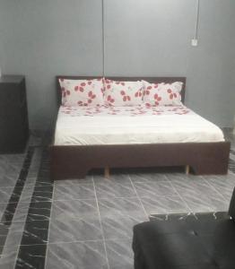 ein Bett mit roten und weißen Kissen in einem Zimmer in der Unterkunft GreenSpring in Cape Coast