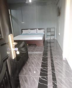 ein Zimmer mit einem Bett und einem gefliesten Boden in der Unterkunft GreenSpring in Cape Coast