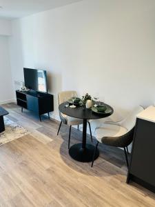a dining room with a black table and chairs at Stylish Modern 1-Bed Apartment in Manchester
