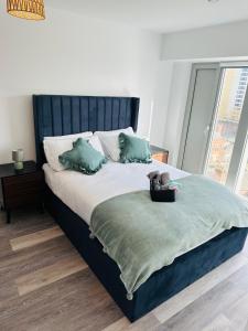 a bedroom with a large bed with green pillows at Stylish Modern 1-Bed Apartment in Manchester