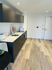 a kitchen with wooden floors and a counter top at Stylish Modern 1-Bed Apartment in Manchester +6 photos