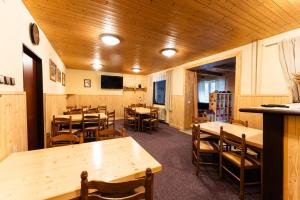 a dining room with wooden tables and chairs at Celá Horská Chata Maty - až 25 lůžek in Dolni Dvur