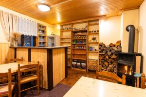 a room with a fireplace and a table and a stove at Celá Horská Chata Maty - až 25 lůžek in Dolni Dvur