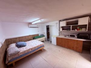 a small bedroom with a bed and a kitchen at ברזיליאנו - Braziliano in Eilat