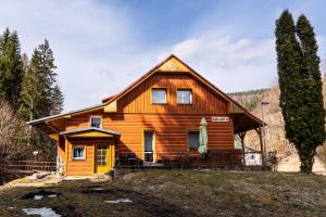 a wooden house with a yellow door on a hill at Celá Horská Chata Maty - až 25 lůžek in Dolni Dvur