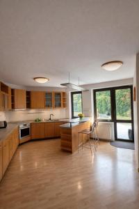 a large kitchen with wooden cabinets and a table at Villa Grande Praha in Prague