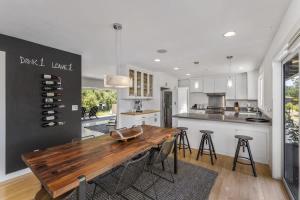 a kitchen with a wooden table and some bar stools at Haven With Pool, Hot Tub And Tastings Included in Healdsburg