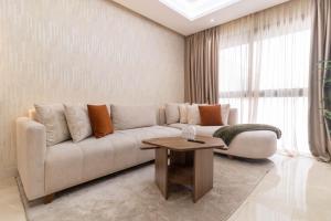 a living room with a couch and a table at Appartement Uptown CFC - Piscine - Gym - Parking Gratuit in Casablanca
