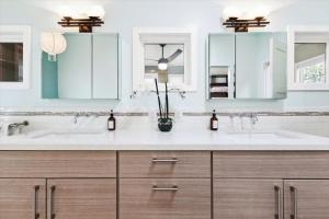 a bathroom with two sinks and two mirrors at Bennett Valley Eden in Santa Rosa